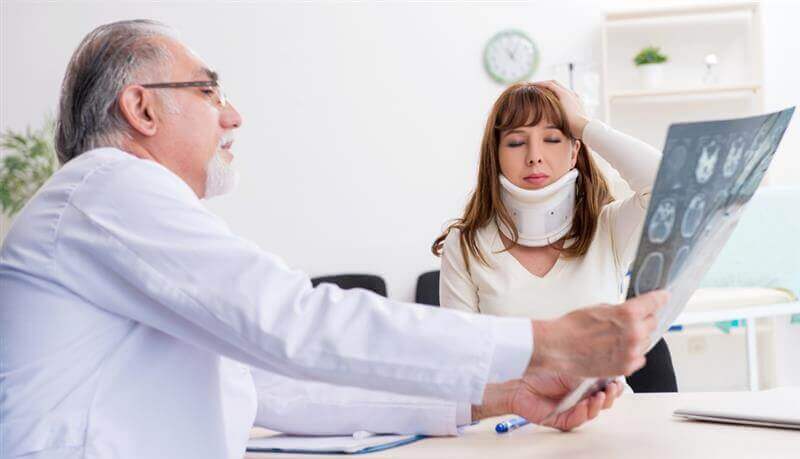 Doctor reading xray results for lady patients injury.