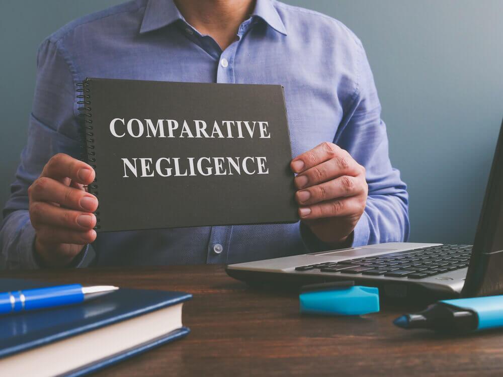 Man holding notes entitled comparative negligence.