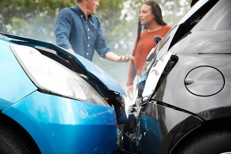 Two angry motorists arguing over responsibility for car accident.