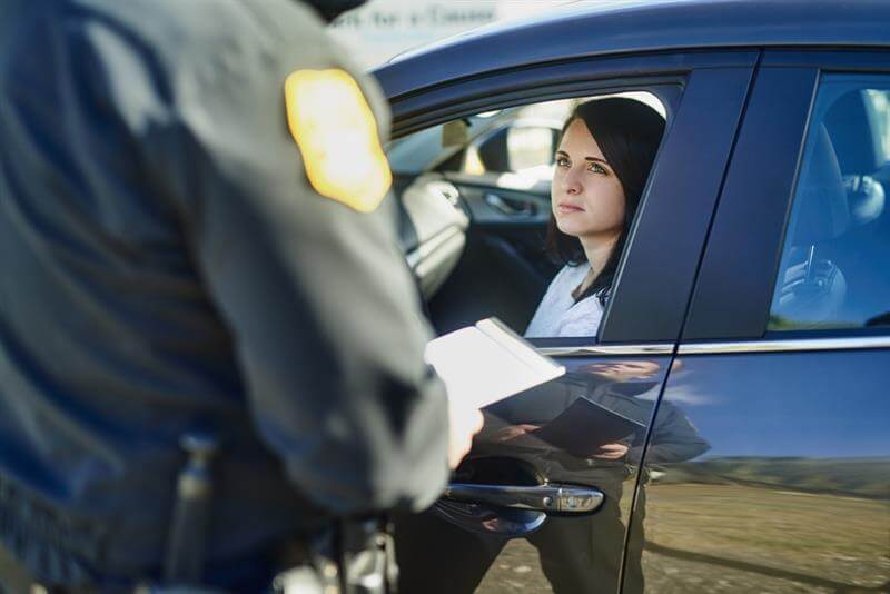 Traffic enforcer issuing ticket to lady driver in the highway for overspeeding.