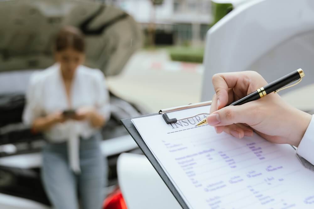 Insurance agent checking car damages.