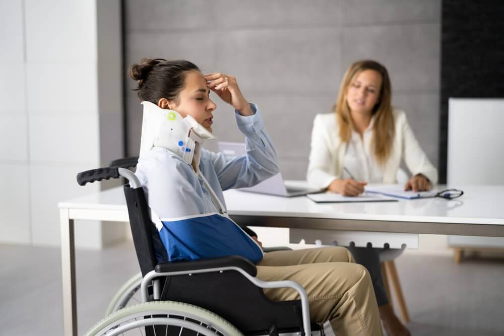 Injured lady with neck braces and on wheelchair filing claims.