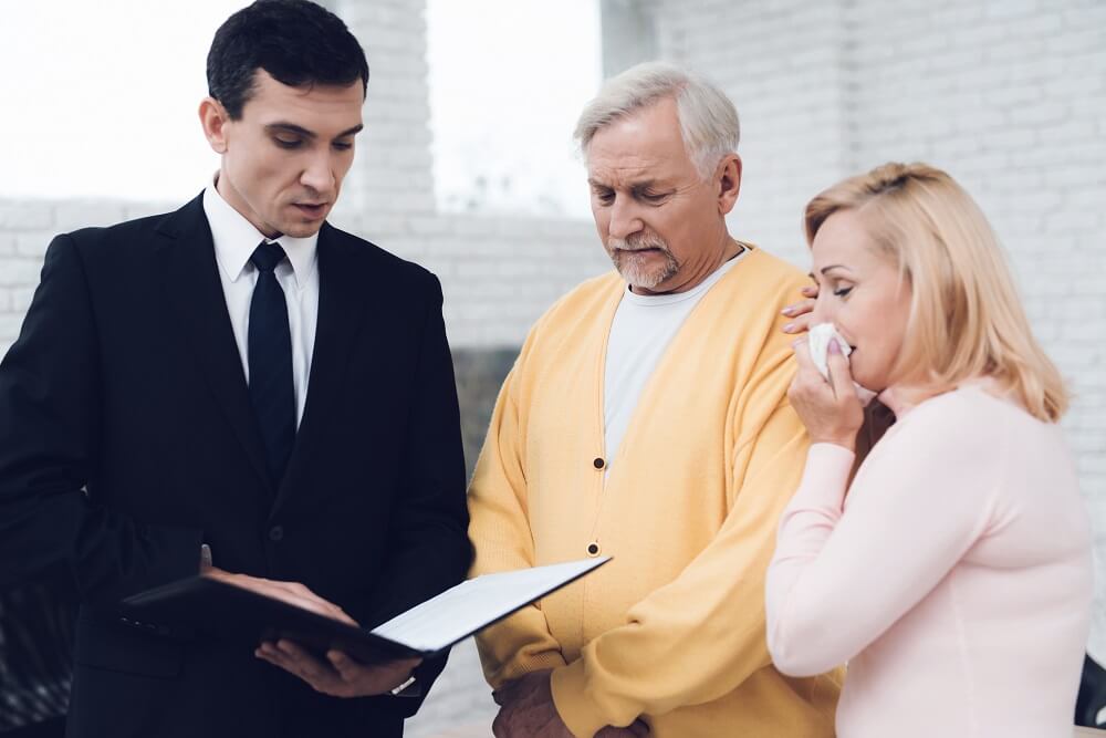 Sad couple listening to lawyer on the last will of their late son.