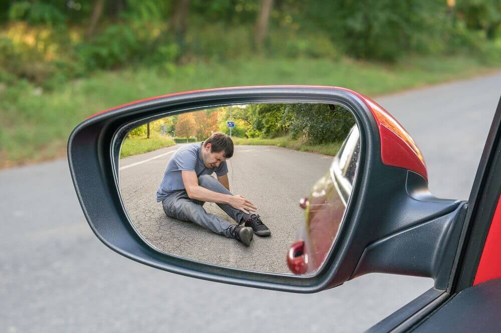 Pedestrian injured in hit and run seen in side mirror.
