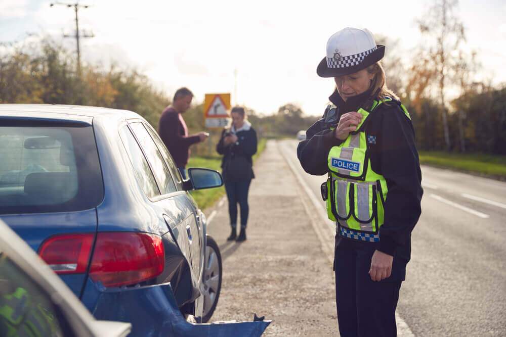 Police officer conducting investigation in car accident.