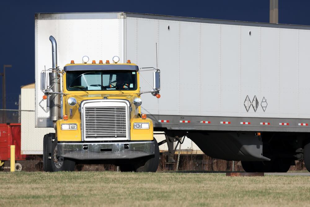 Wide turn commercial truck in the highway.