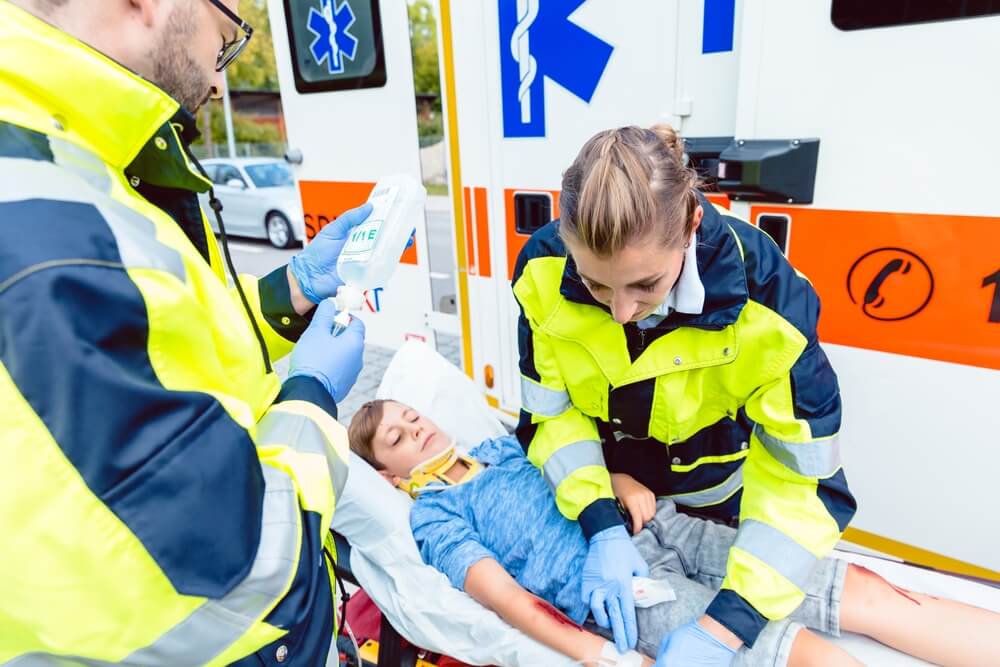 Paramedics rescuing injured kid from car accident.