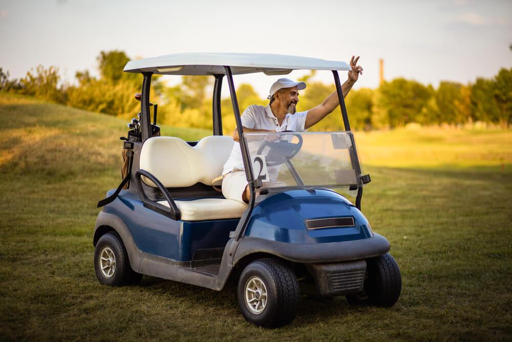Happy Senior man in golf cart.