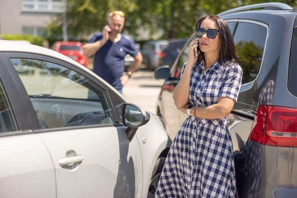 Lady driver calling her insurance company to report accident.