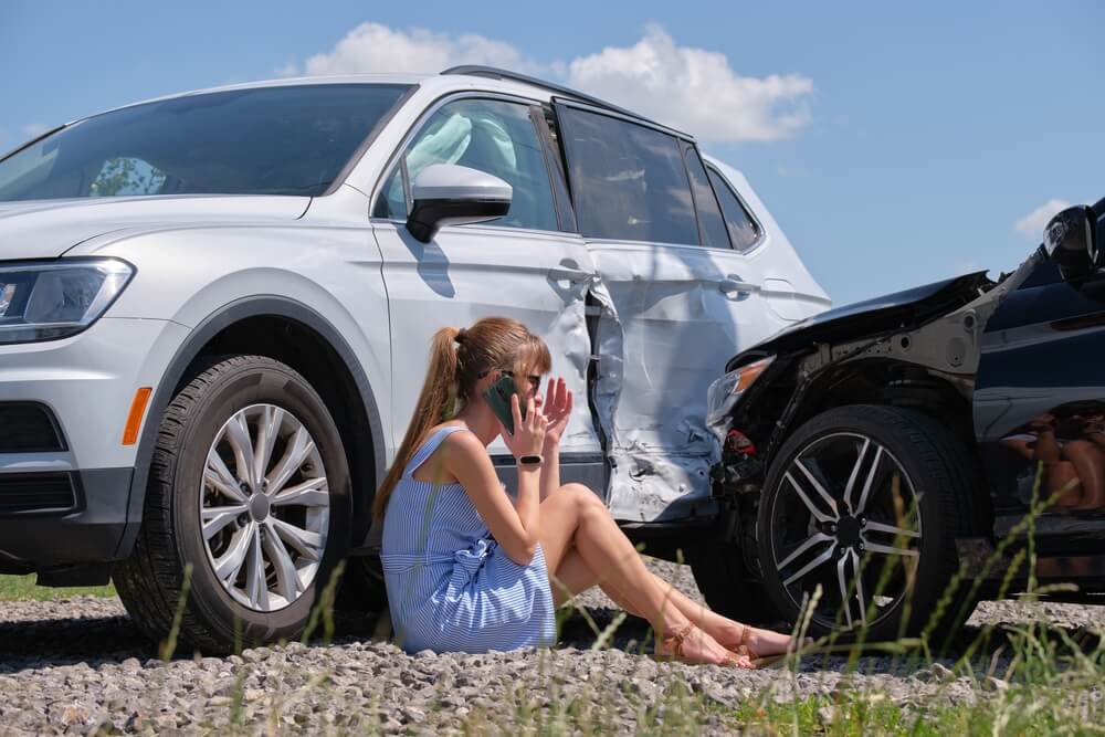 Stressed woman driver talking on phone to report accident.
