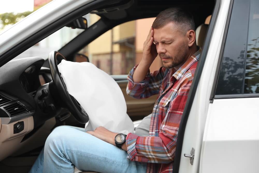 Injured man suffering concussion opened airbag in automobile after car accident.